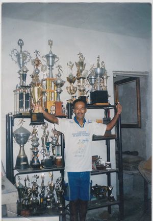 Fotografia tirada na casa de Antonio, com alguns dos troféus recebidos ao longo da sua vida. O fotógrafo Tião Moreira tirou essa fotografia para matéria na Revista Contra Relógio.