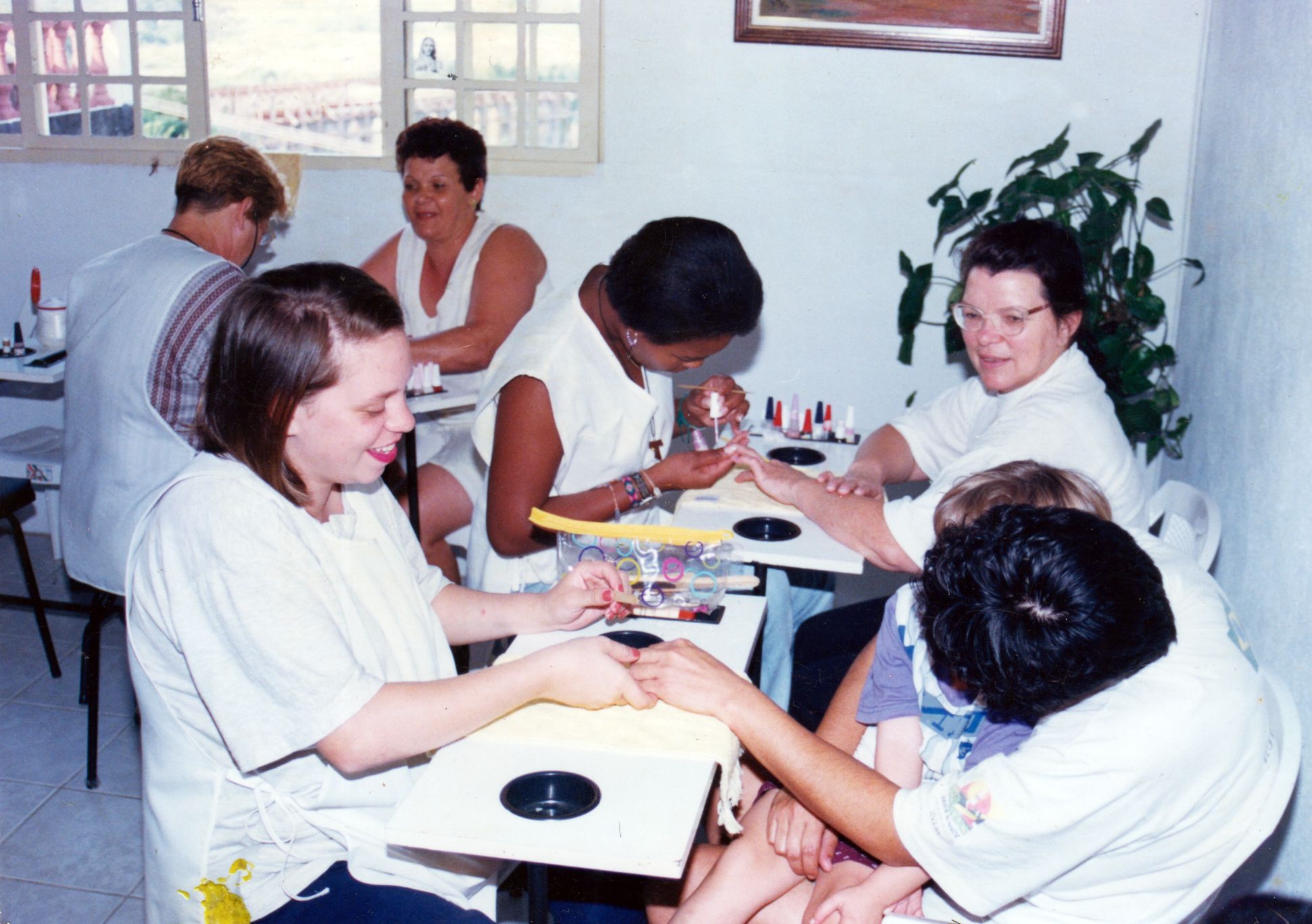 Karina se prepara no curso profissionalizante de manicure oferecido pela Prefeitura de Embu das Artes. Karina está no segundo plano da foto, do lado esquerdo.