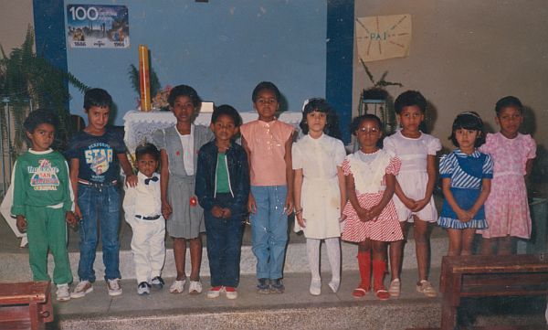 No dia do batismo, André é fotografado com a família e amigos. Da esquerda para a direita:  André (terceiro), a irmã Karina (terceira), a irmã Maísa (sexta) e a prima Adriana (oitava).