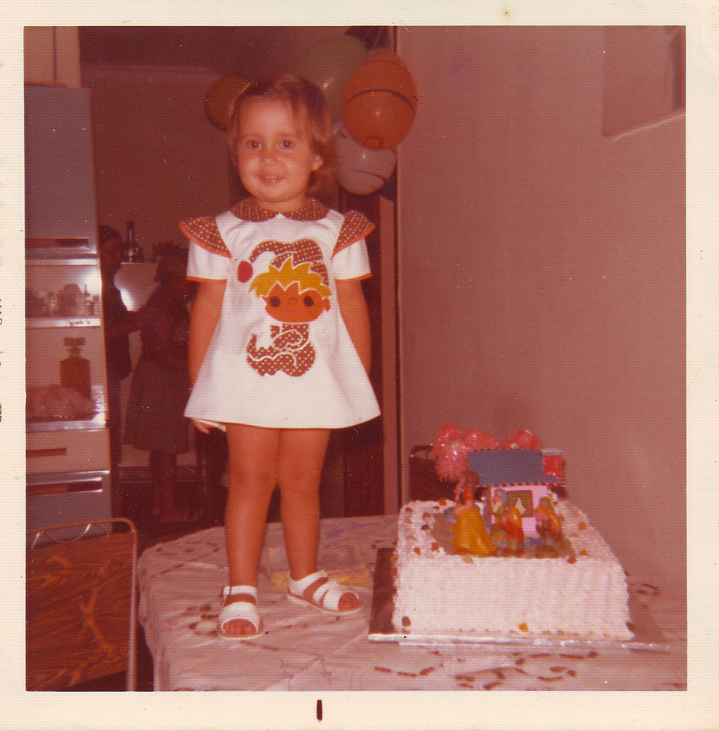 Em cima da mesa, Rafaela comemora o seu aniversário de dois anos.