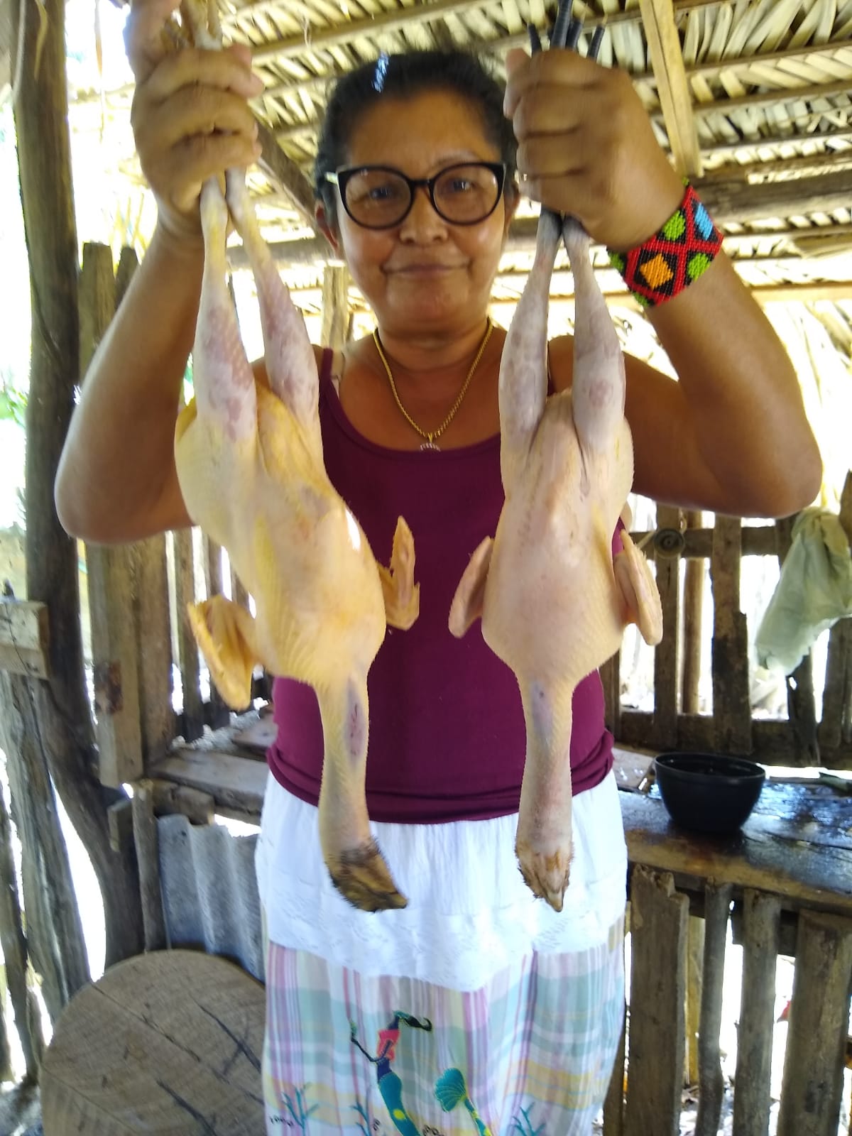 O pai de Luakam cria galinha caipira em seu quintal e geralmente quando ela chega na casa de seu pai ele pede para ela preparar galinha caipira, um prato típico paraense, para comerem. No dia dessa foto Luakam estava preparando o almoço. Para ela, esta foto representa a coletividade, porque há um costume de cozinhar com a participação de todos.