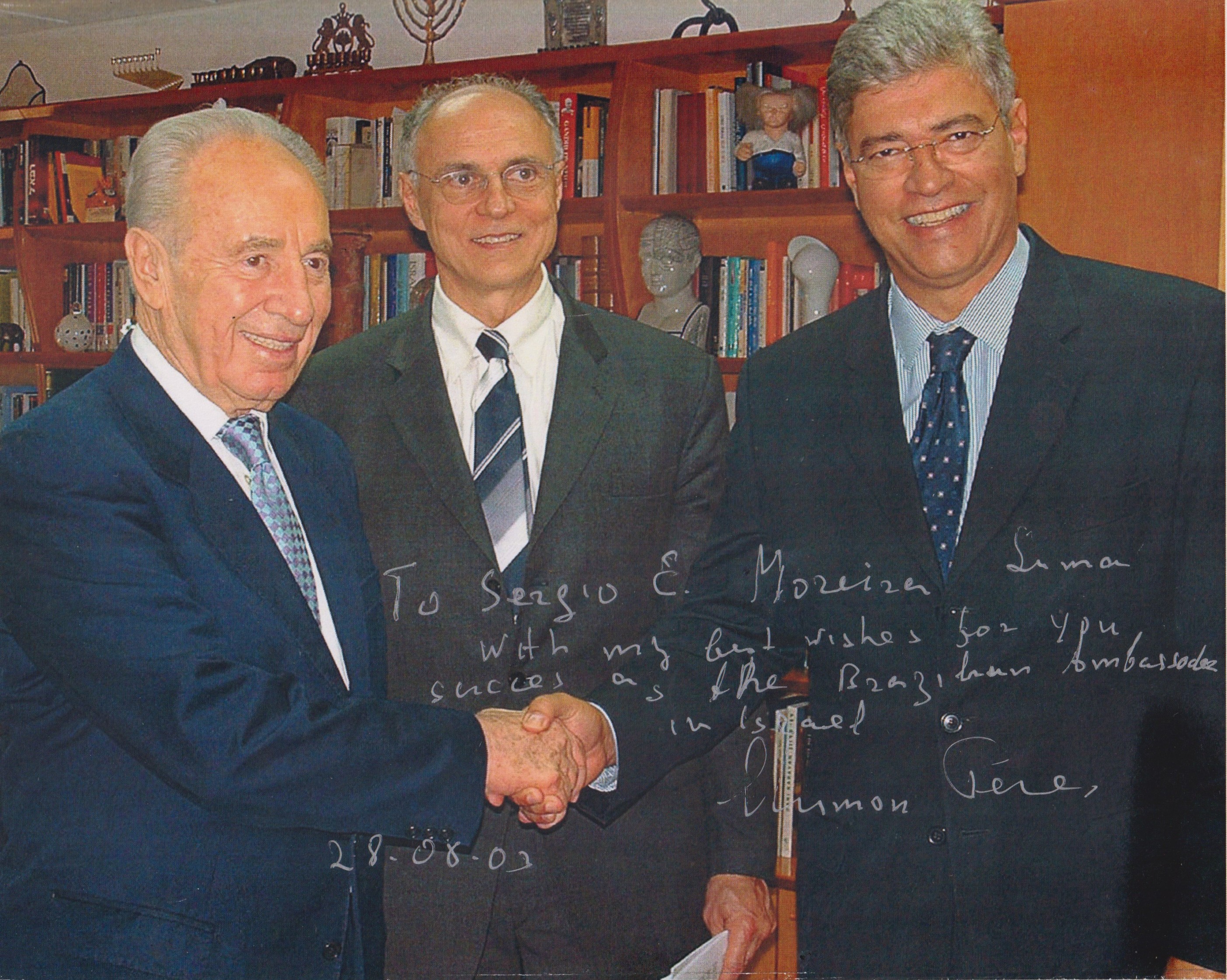 Foto que registra o momento em que o embaixador brasileiro em Israel, Sérgio Eduardo Moreira Lima, cumprimenta o ex-primeiro ministro israelense Shimon Perez. Este encontro aconteceu por ocasião da visita oficial do senador Eduardo Suplicy, em 2003, então presidente da Comissão de Relações Exteriores do Senado.