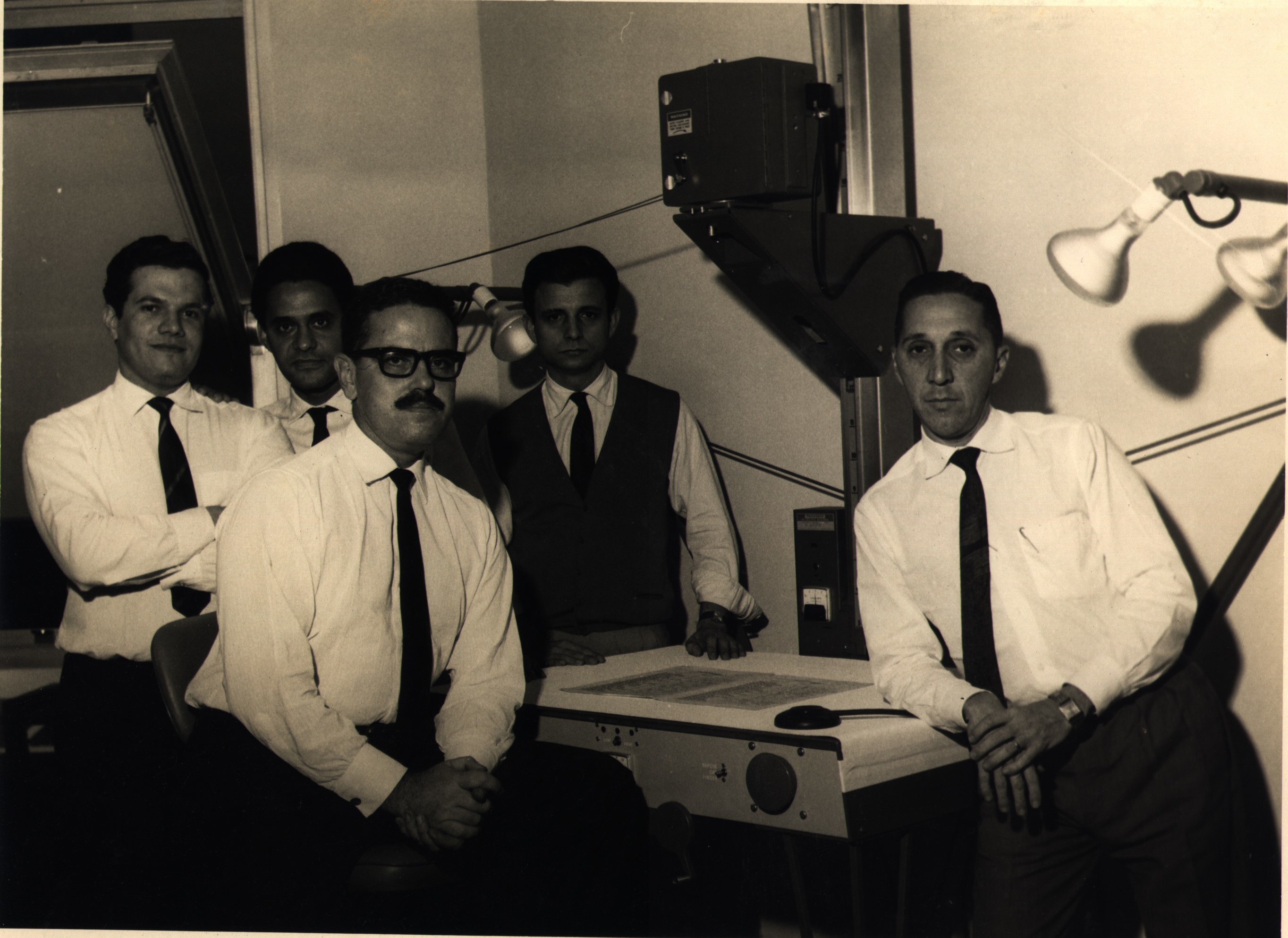 O BNDE foi um precursor do sistema de microfilmagem e possuía, no prédio da Avenida Rio Branco, o sistema mais moderno do Brasil segundo a Kodak. Henio estava presente na inauguração do sistema. Esq.-dir.: Aluísio, Valter, Antônio Augusto, Orlando, Henio.