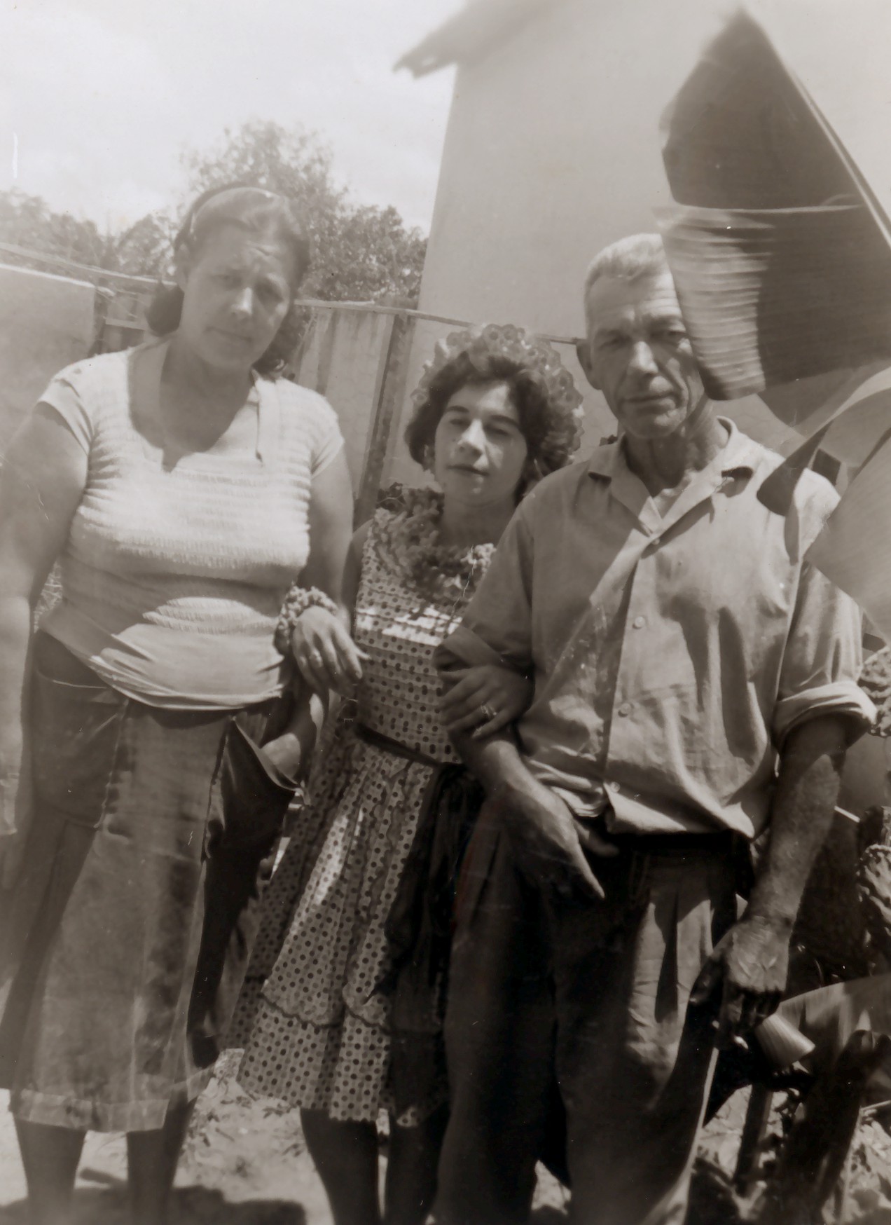 Déa (ao centro), junto à madrasta Marieta e o pai Décio, no quintal de sua casa, vestida a caráter para ir à Festa Junina da Companhia de Telecomunicações do Brasil Central (CTBC).