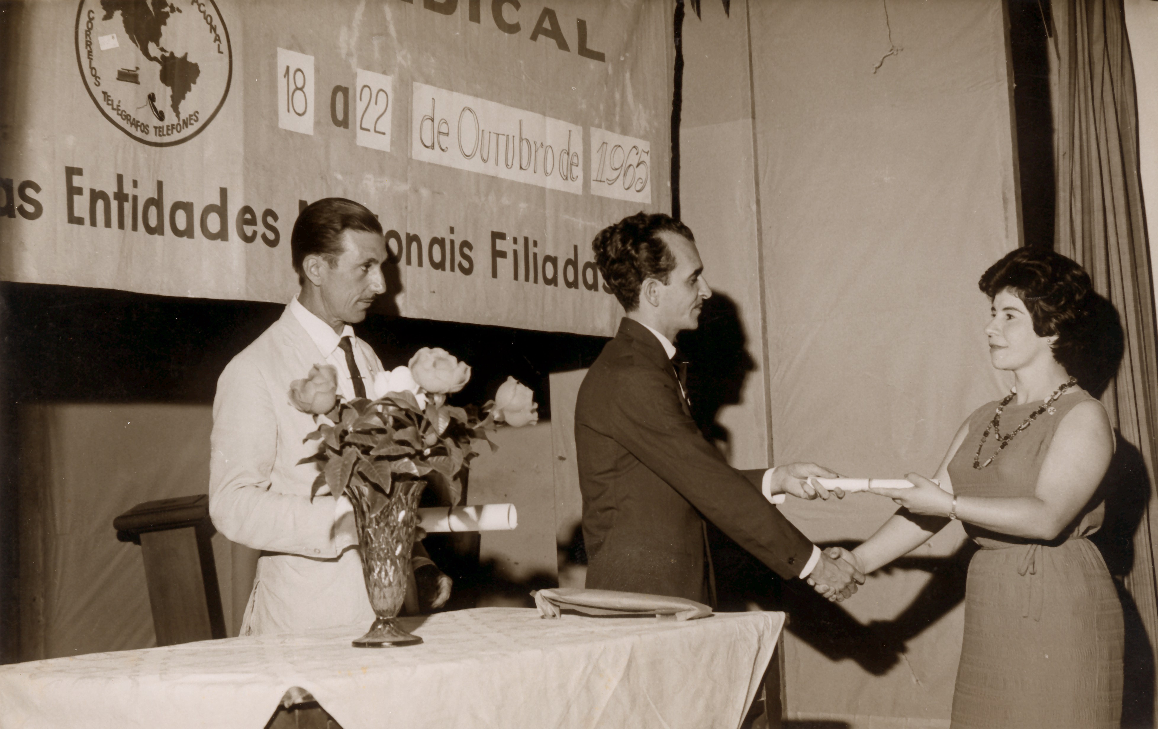 Déa recebe o certificado de participação na reunião do Sindicato de Trabalhadores em Telecomunicações de Carloto, representante do sindicato de Belo Horizonte.