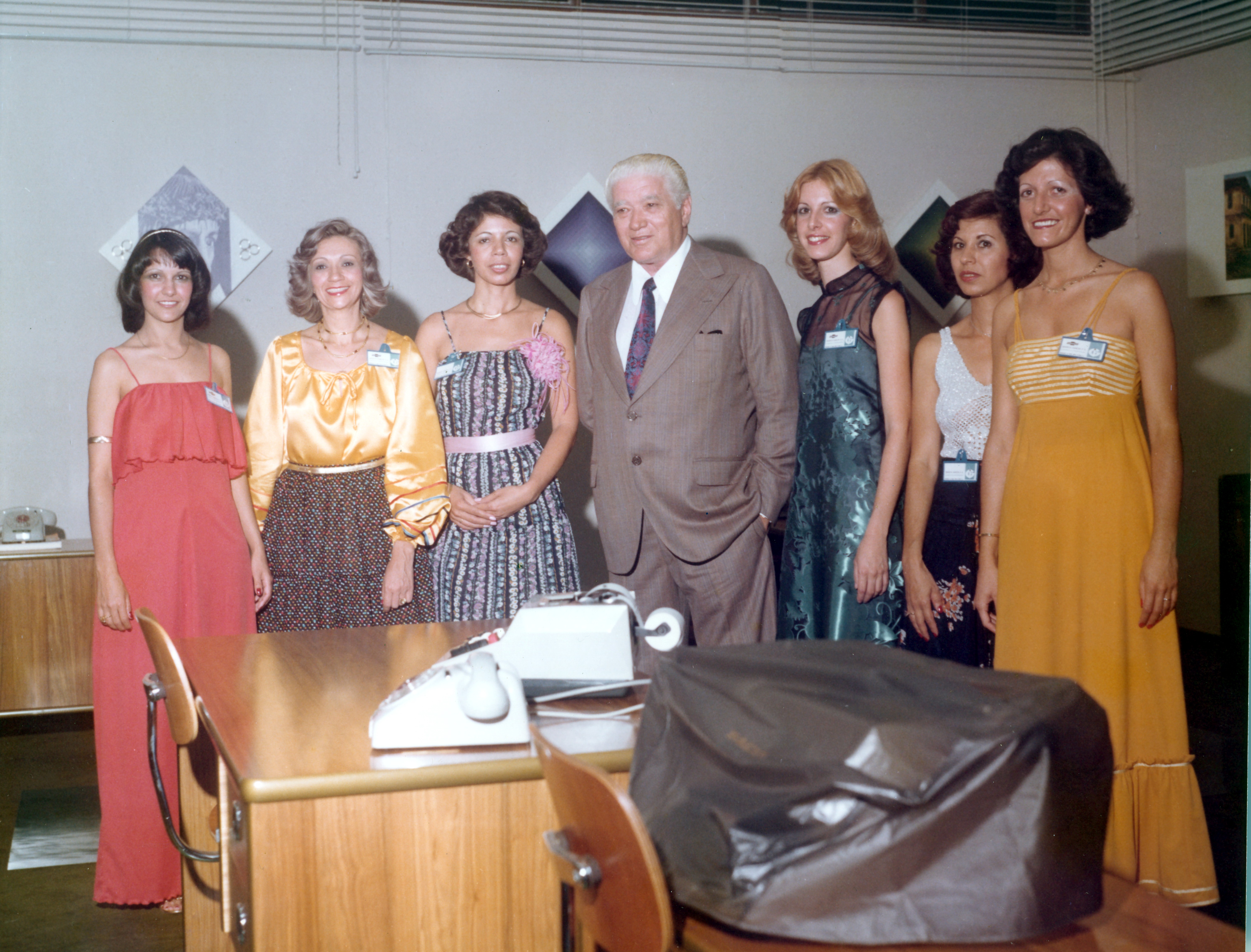 Mirna e colegas de escritório posam com o senhor Agenor em retrato de inauguração da loja da ABC Irmãos Garcia, onde funciona o centro administrativo. Esq.-dir.: Amélia, Marlene, Mirna, Agenor, Marília, Maria Vera e Terezinha Almeida.