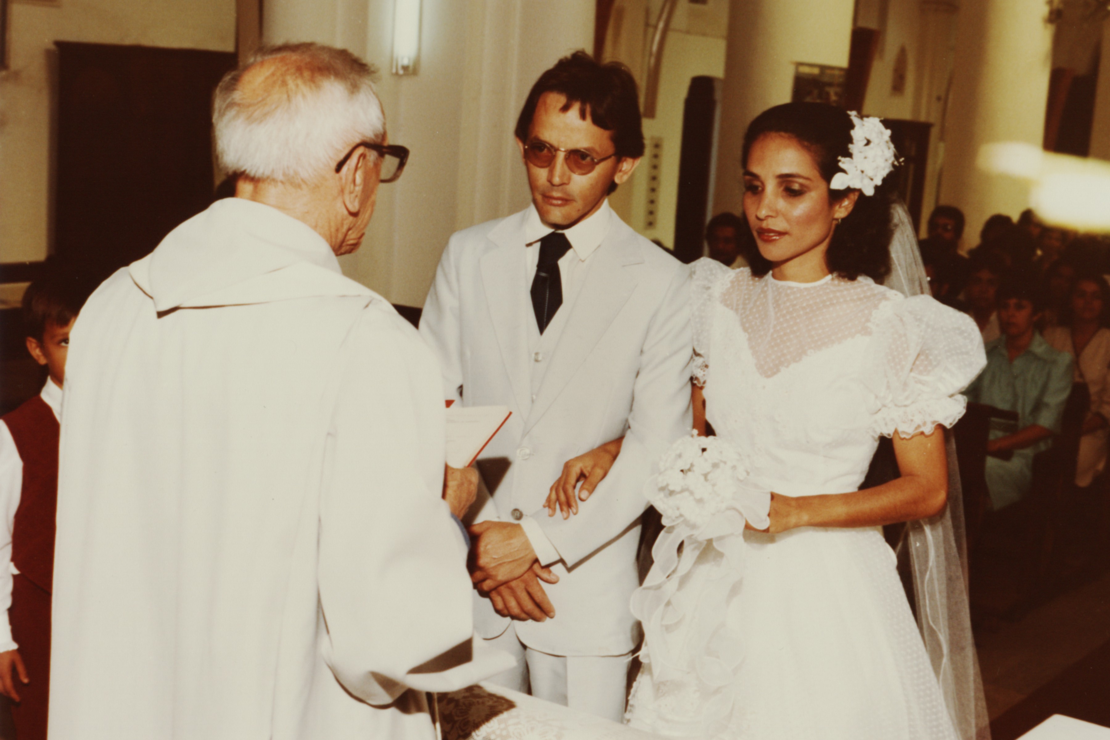 Casamento de Tarso e Vanila, eles estão no altar, de frente para o padre que está realizando cerimônia