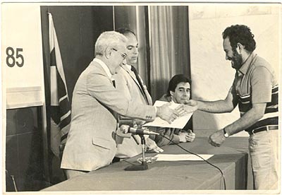 Adonias recebendo um diploma como prêmio de Operário Padrão no Salão de Convenções do Hotel (Géoria?).