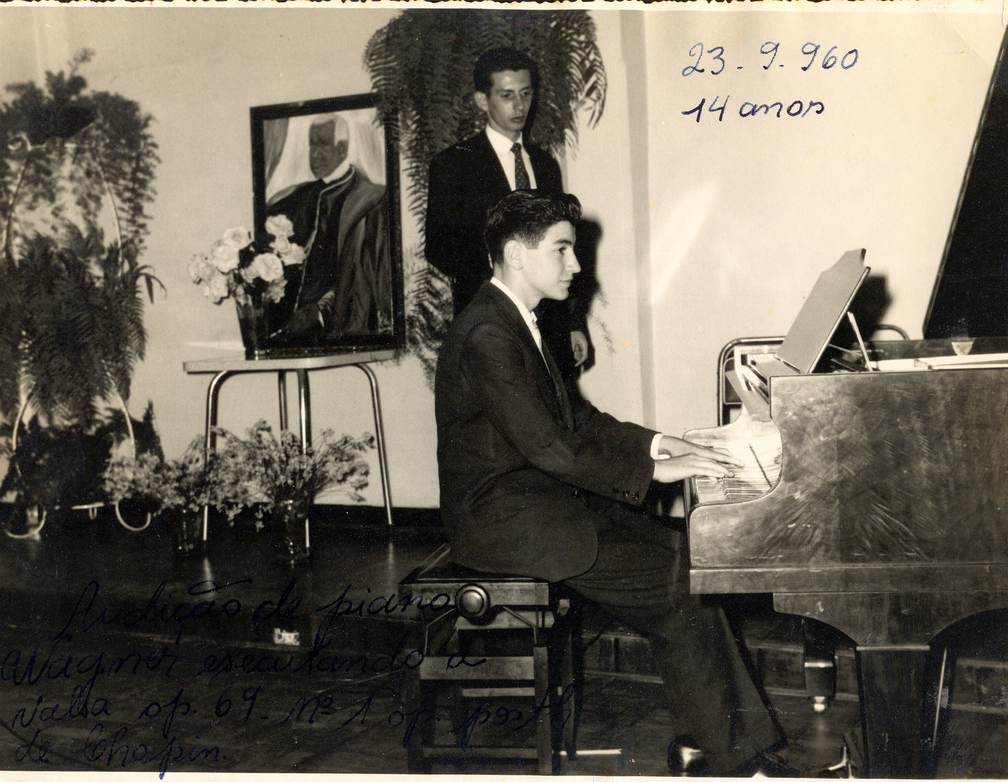 Audição de piano de Wagner Tiso no Automóvel Clube. A mãe e professora de Wagner, Walda Tiso, realizava no Automóvel Clube de Três Pontas, estas audições de música com os filhos. Nesta, Wagner executa a valsa op. 69 N.º 1 op. Posth de Chopin.
Wagner, pianista, tecladista, compositor, arranjador, maestro e diretor musical nasceu em Três Pontas em 12/12/1945. Aos quatro anos de idade, Wagner já tocava piano à quatro mãos com seu irmão Gileno. Vindo de uma família onde a musicalidade era latente, iniciou seus estudos na música primeiro através de sua mãe Walda, e mais tarde através de sua tia Ruth, que então já procurava conter sua tendência ao improviso, traço de sua personalidade marcada pelo contínuo aprendizado e pelo amor incontrolável pela música.