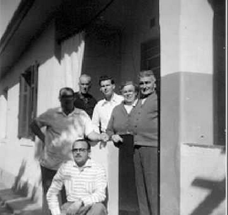 Luciano Strambi (agachado) ao lado dos pais e amigos durante almoço.