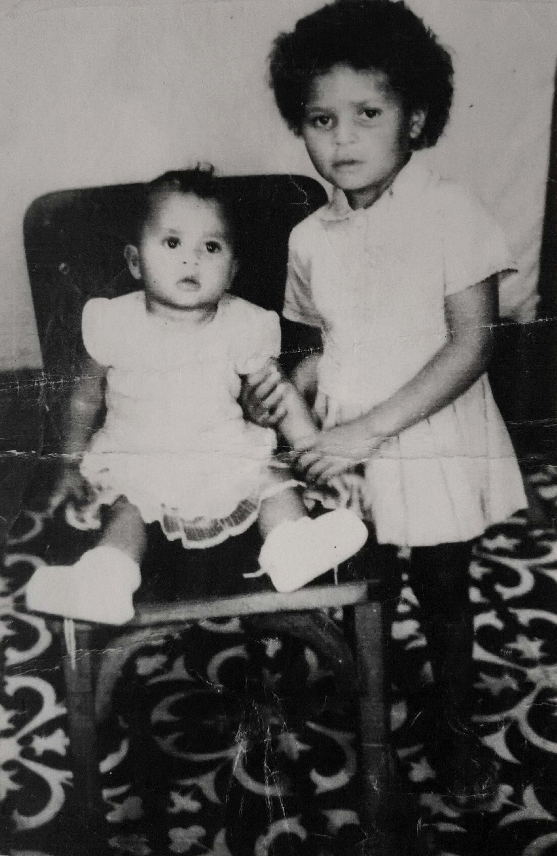 As irmãs Adriana e Marisa, ainda meninas em Pernambuco, lado a lado em um retrato cheio de ternura. Anos depois, já adultas, dividiram sonhos e desafios na Vila Esperança, em Cubatão. Naquele instante da infância, não podiam imaginar os caminhos que o futuro lhes preparava, mas a força do laço entre irmãs sempre esteve presente.