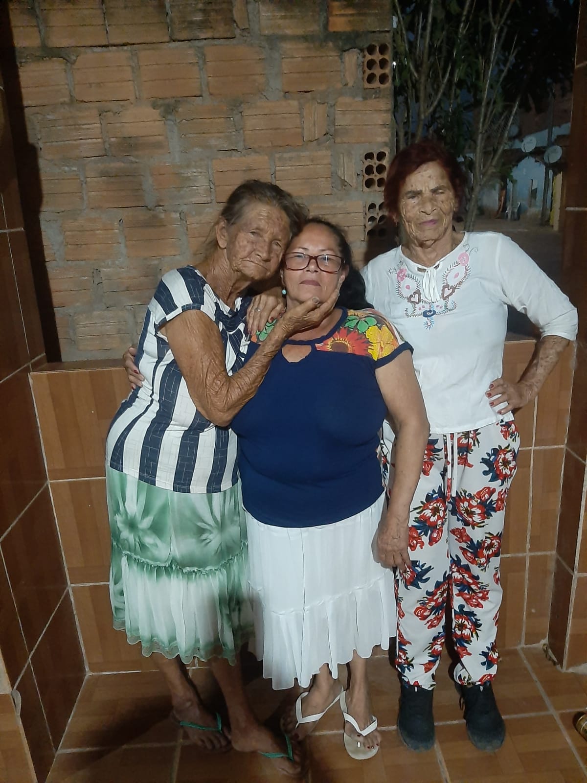 Fotografia de Edite com suas irmãs, Creuza e Helena, durante viagem a Penedo, cidade natal em Alagoas. O encontro representa o reencontro com suas origens e os laços familiares que permanecem vivos ao longo do tempo.