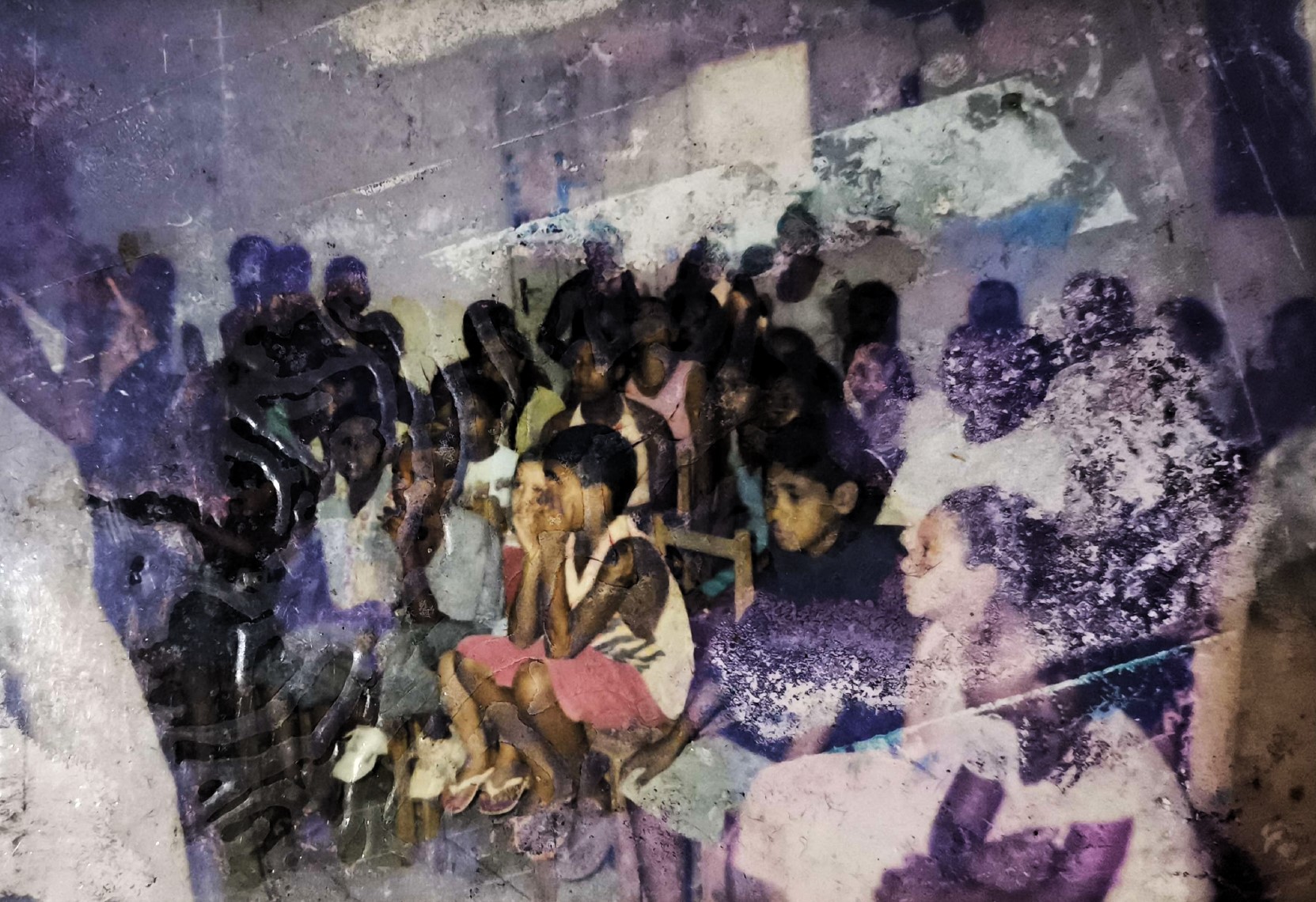 Na imagem, Andinho está com a cabeça baixa, em um gesto que pode indicar reflexão ou introspecção. O ambiente é o mesmo da imagem anterior: uma aula possivelmente vinculada a iniciativas sociais dos anos 90, na Vila Esperança, em Cubatão, conduzidas por Zumbi, liderança comunitária local. A cena registra a presença ativa de Andinho em um contexto de formação e engajamento comunitário.