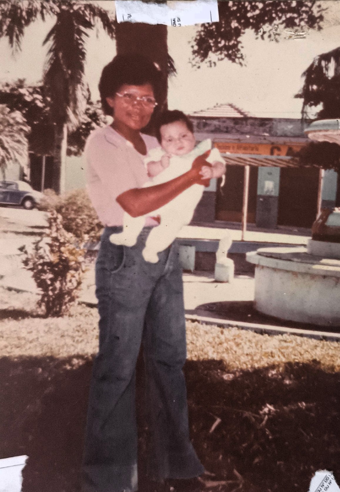 A imagem retrata Dona Cícera segurando nos braços seu filho Plínio, ainda recém-nascido, no final dos anos 1970. O registro carrega a delicadeza do início da maternidade e marca o surgimento de uma nova geração na Vila Esperança, em Cubatão. Em um contexto de forte vínculo familiar e comunitário, a cena revela o cuidado e a presença constante de Cícera na formação de seus filhos, em meio a um território ainda em processo de ocupação e transformação.