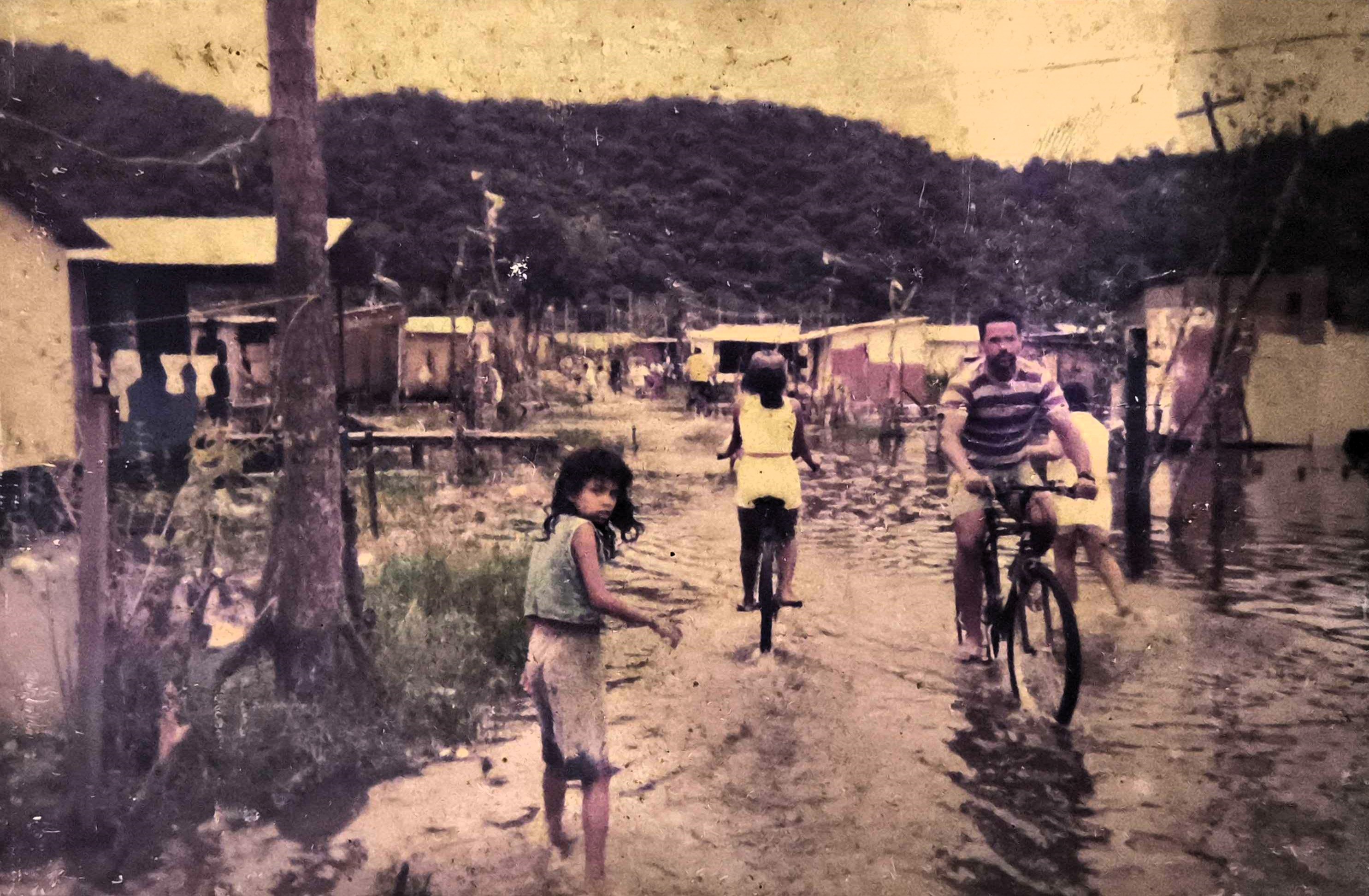 Fotografia que registra a precariedade do bairro Jardim Ilha Bela, na Vila Esperança, nos primórdios de sua constituição. O cenário revela as condições frágeis de moradia enfrentadas pela comunidade, marco do período em que Zumbi, ainda muito jovem, percebia a urgência de lutar por estrutura, dignidade e melhorias coletivas. A imagem se torna um testemunho visual de um território vulnerável, mas também de uma juventude que começava a se mobilizar para transformar o seu entorno.