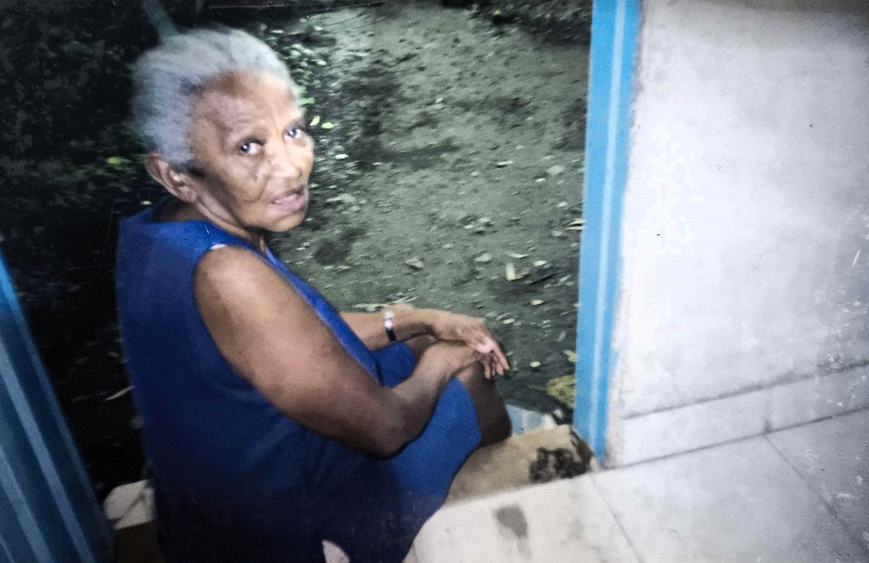 A fotografia mostra Dona Martinha sentada à porta de sua casa, em um momento de descanso. Líder comunitária, ela dedicou a vida à luta por melhores condições para sua comunidade na Ilha Bela. A pausa capturada na imagem destaca sua força, sua jornada e o impacto profundo de sua atuação na Vila Esperança.