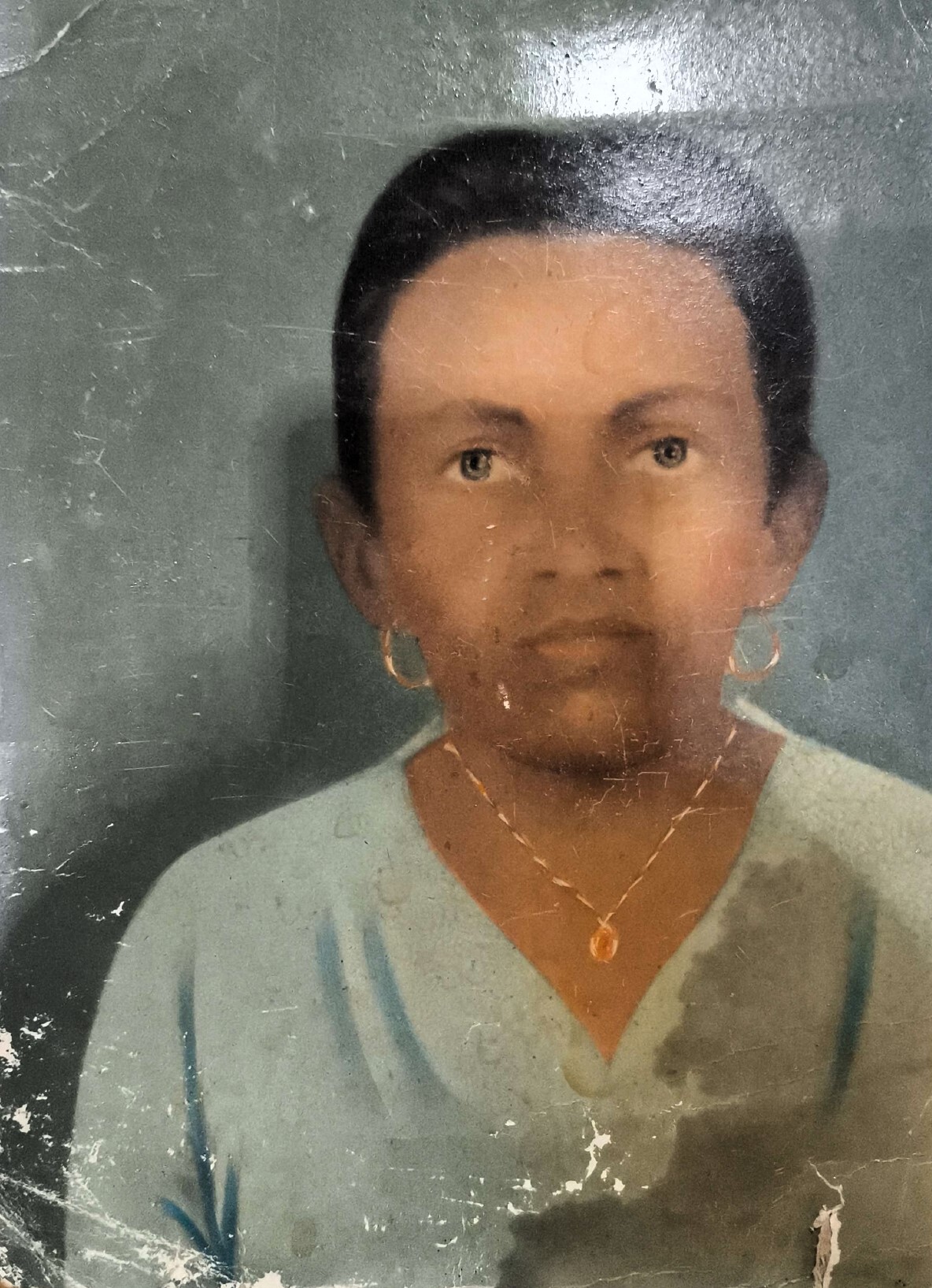 Neste retrato antigo, feito no estilo tradicional das fotografias brasileiras que eram retocadas manualmente com pintura, vemos Dona Martinha, mãe de Zumbi, figura central na memória afetiva da Vila Esperança. Sua imagem, preservada com cuidado pelo filho, carrega marcas de tempo, devoção e pertencimento. Para além de um registro familiar, o retrato se tornou um símbolo comunitário: representa a força de uma mulher que exerceu liderança, acolheu vizinhos e ajudou a moldar o cotidiano do bairro.