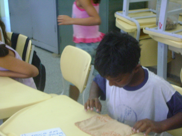 personagem: Kleber<br>historia: O aluno está vendo o lenço que foi bordado por D. Hilda quando ela tinha 11 anos<br>