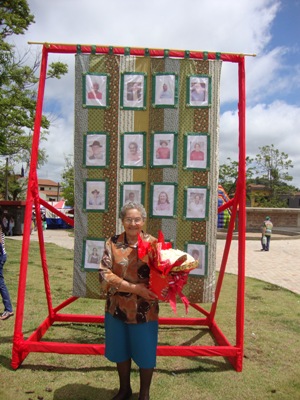 personagem: Dona Alaide<br>historia: Dona Alaíde em frente a colcha de retalhos<br>