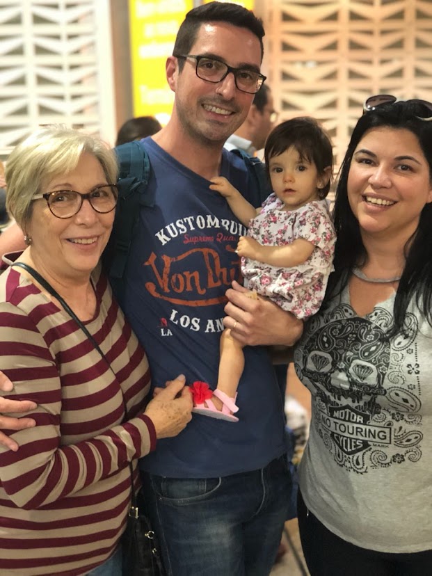 Descrição: Carlos Eduardo com sua mãe Eugênia, irmã Juliane e afilhada Laís no aeroporto de Guarulhos, durante sua ida para a Colômbia. Para ele, a fotografia representa o apoio que elas sempre dão em sua vida.