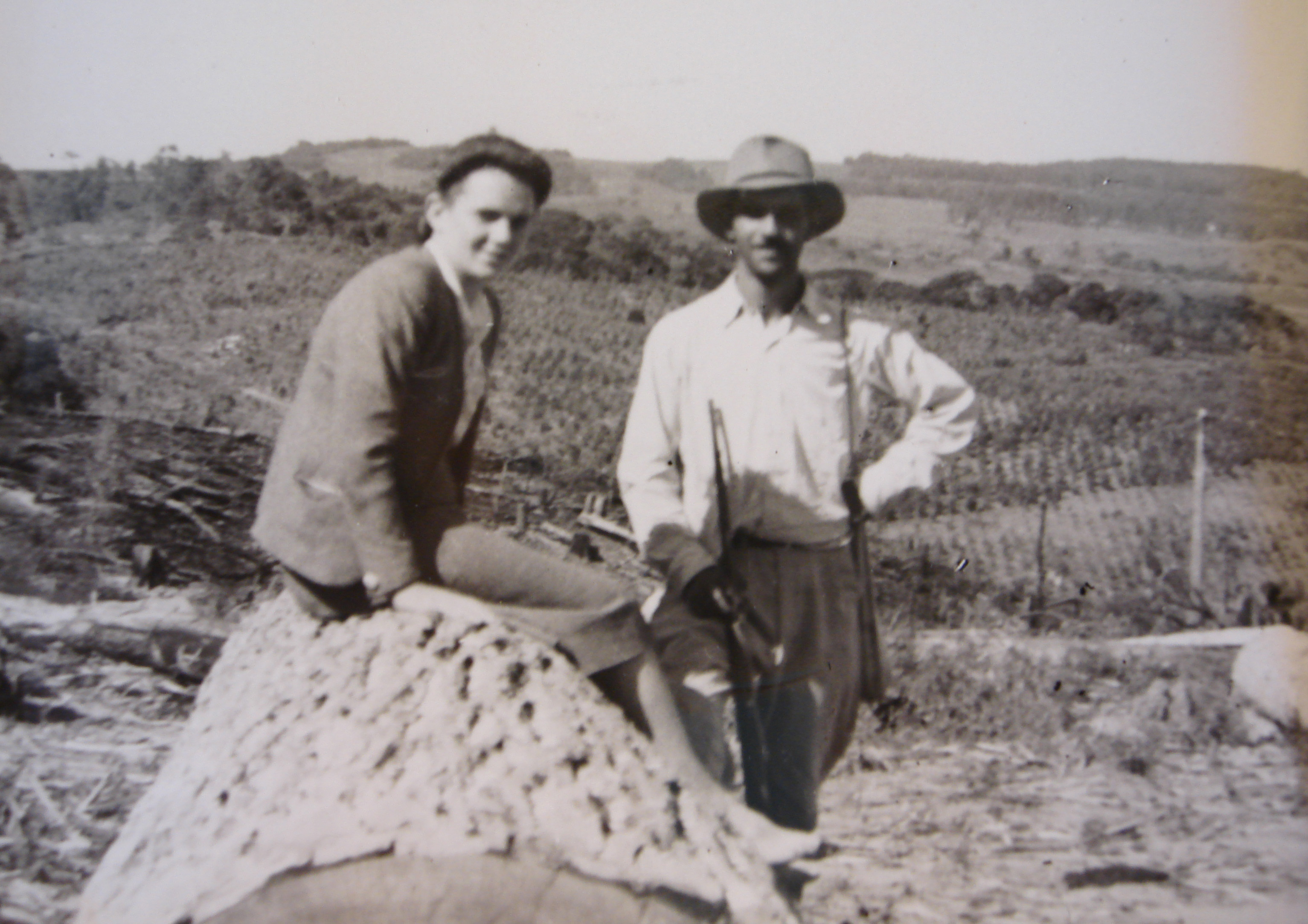 Octávio Pereira Lima e Eunice Ribeiro do Valle, pais de João, são retratados em um momento de pausa durante uma derrubada na fazenda. A imagem revela o casal em posição de descanso, cercado pela vegetação e pelos vestígios do trabalho rural, em meados dos anos 40.