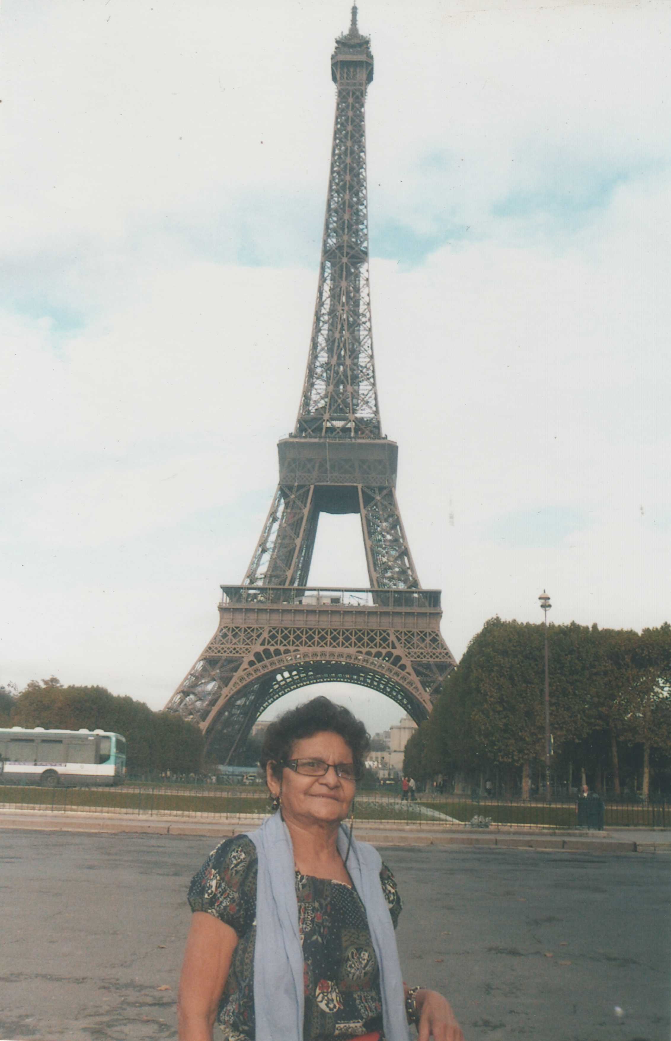 Cleta posa para foto em frente à torre Eiffel, em uma das suas viagens.