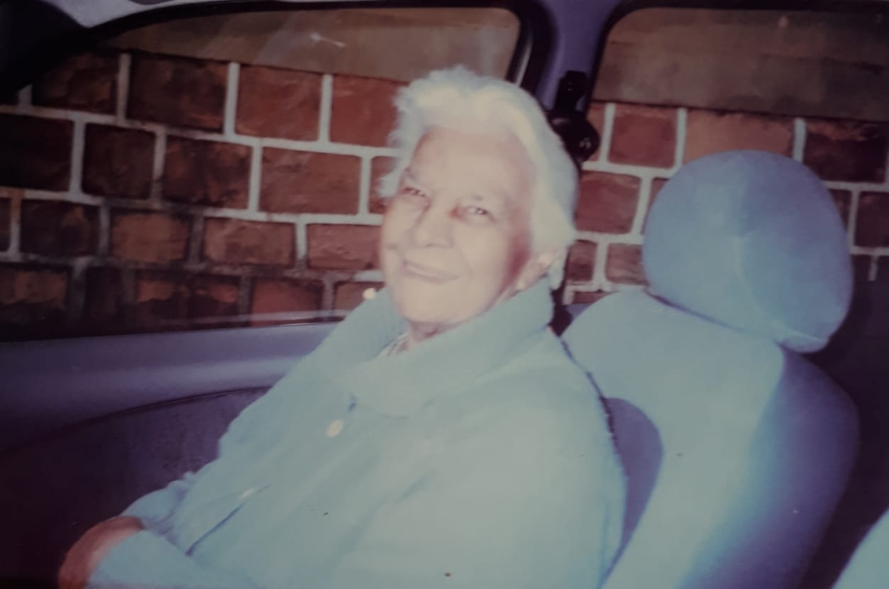 A avô paterna de Guilherme, Maria do Carmo, dentro do carro do neto, em Ribeirão Bonito, SP. Guilherme e sua irmã eram os únicos netos de Maria do Carmo, que faleceu em 2001. Na época da fotografia, a avó já tinha a mobilidade reduzida e Guilherme a levou passear em seu Ford Fiesta. Ele conta que, em 2019, a sua jornada de eventos sobre Diversidade o ajudou a resgatar a história da avó, seus traços, sua trajetória e os não lugares que ela enfrentou durante sua vida.