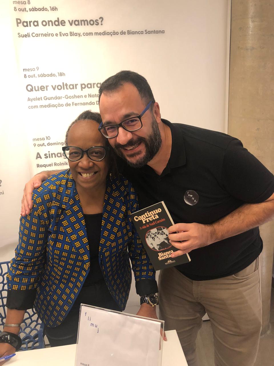 Guilherme e Sueli Carneiro durante uma mesa redonda no Museu Judaico de São Paulo, o reencontro presencial dos dois após a pandemia. Guilherme conta que essa fotografia é importante pois simboliza o afeto, amor, respeito e admiração que ele nutre por Sueli, que sempre é muito generosa com ele. Nesse dia, ela escreveu a dedicatória “Gui, meu amor, meu tesouro” no livro sobre sua história: Continuo preta: A vida de Sueli Carneiro e o entregou.