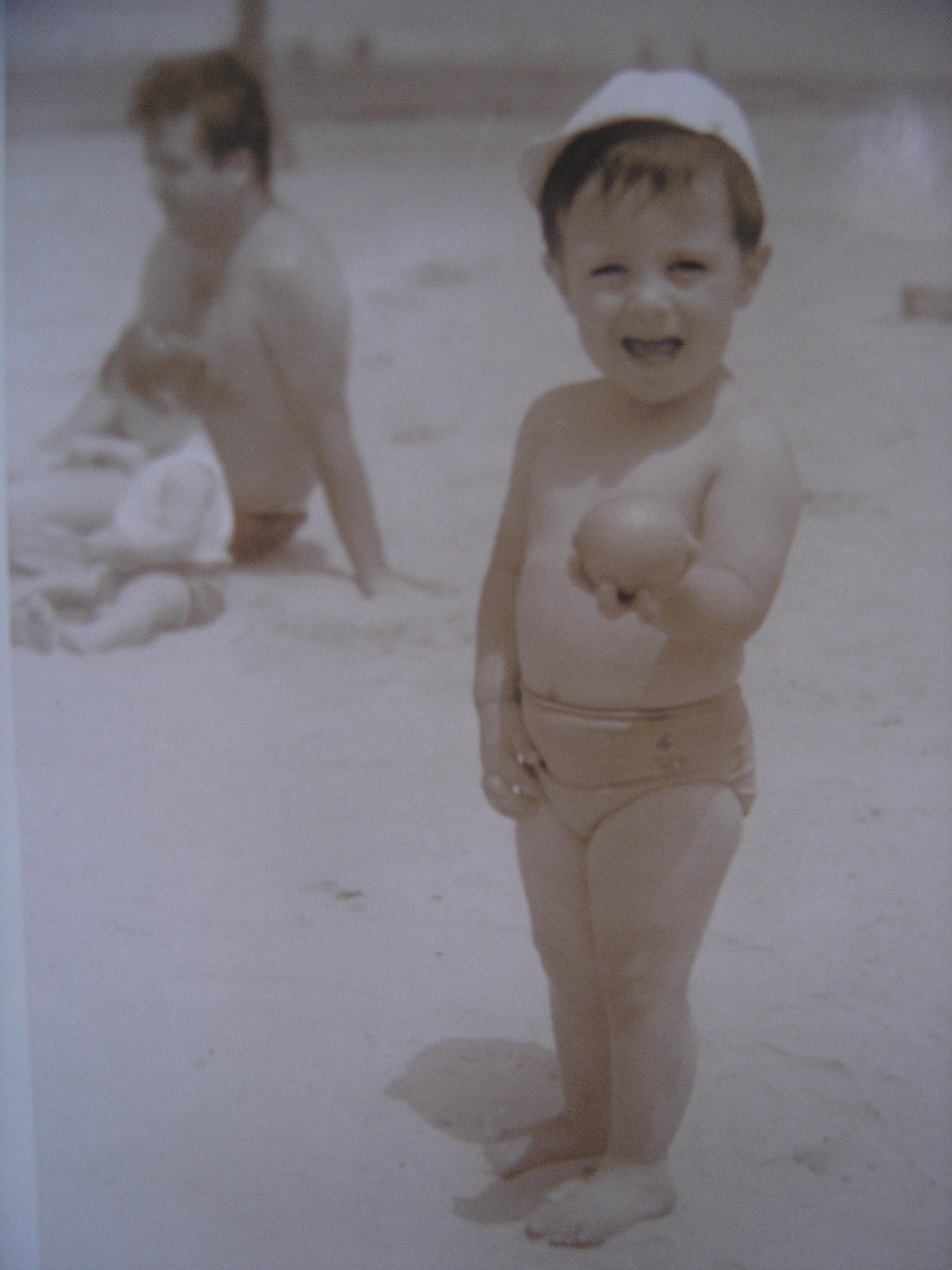 Marcelo, quando pequeno, brincando na areia da praia.
