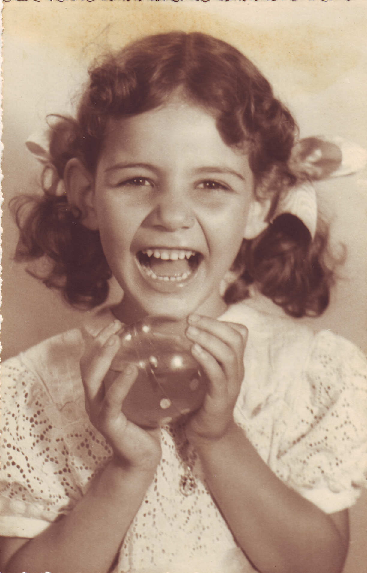 Anna sorrindo em foto de infância.