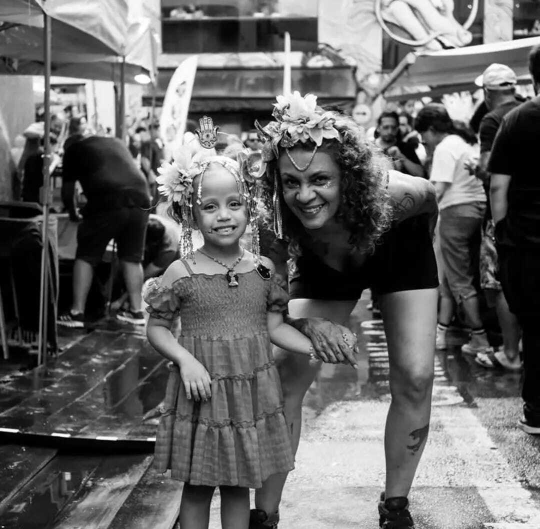 Na foto de Carnaval, Cíntia e a neta Maria Luiza aparecem fantasiadas, celebrando juntas uma tradição que atravessa gerações. Desde criança, Cíntia viveu o carnaval como festa de rua, marcada pelo samba que embalava seu pai e pelas fantasias costuradas pela mãe para toda a vizinhança. Hoje, ao lado da neta, revive essa paixão em forma de alegria compartilhada: o carnaval que antes era dela, agora é delas.