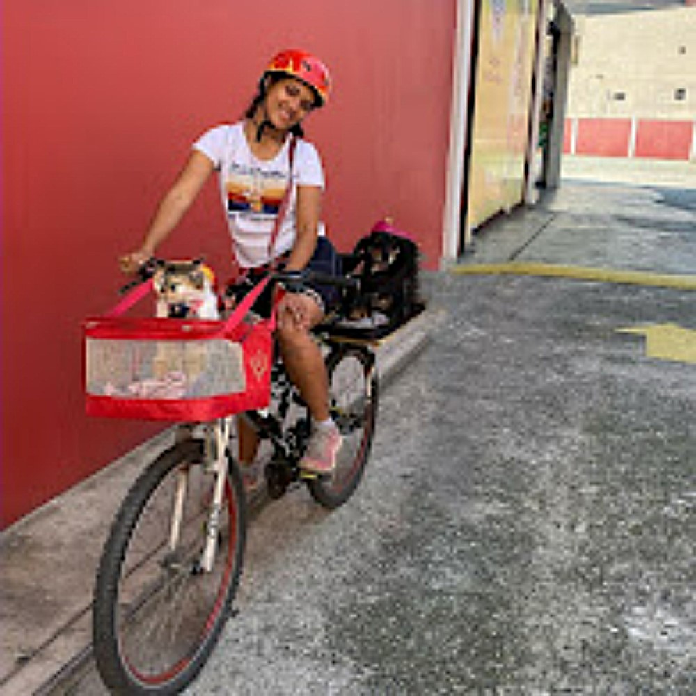 Essa imagem se tornou tão significativa para Rafaela que acabou virando uma tatuagem. O registro foi feito na loja Pet Maxi, na Freguesia do Ó, bairro onde ela morava. Antes mesmo da gata entrar em sua vida, aquele lugar já era um ponto de parada durante os passeios de bicicleta com a cachorra Mel na garupa. Foi ali também que Rafaela comprou alguns porquinhos-da-índia, incluindo a Mel Pig, e onde ela e sua cachorra já eram bastante conhecidas. Nesse dia, pediu ao segurança da loja que tirasse uma foto para guardar de lembrança, especialmente porque, em algumas ocasiões, levava também a gata na garupa. A imagem, simples e afetiva, acabou se transformando em símbolo de uma fase marcante de sua vida.