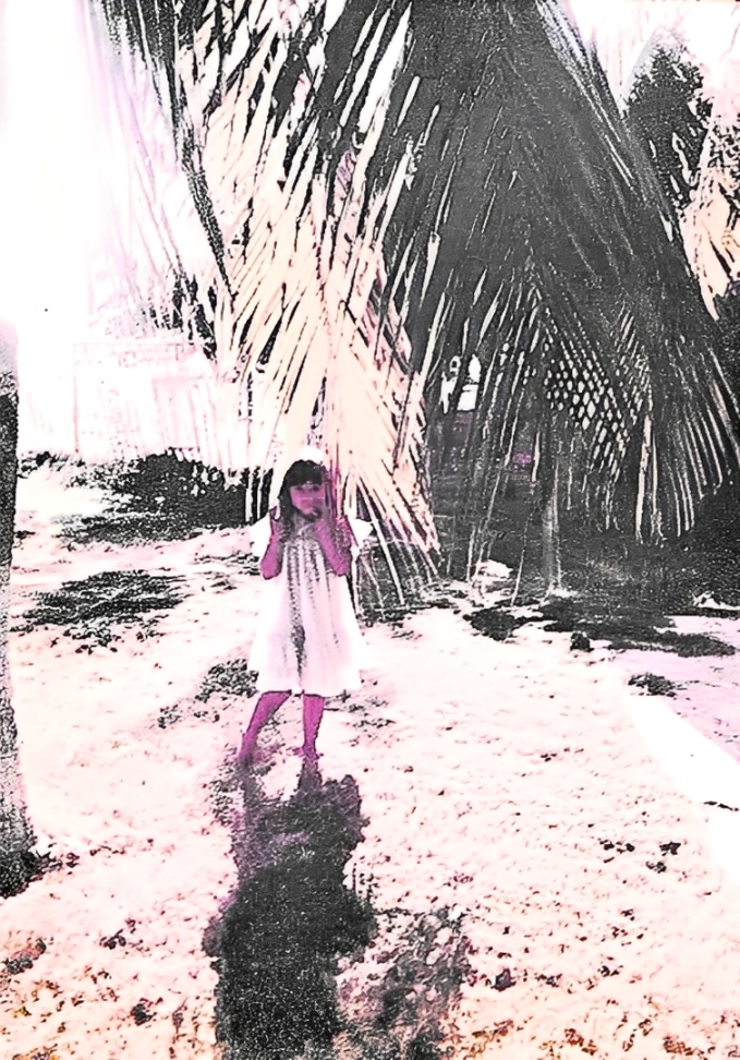 A imagem foi registrada no quintal da casa em Cabimas, próxima ao Lago de Maracaibo, e evoca um período de felicidade vivido por Oriana na infância. A fotografia guarda a memória dos dias passados brincando perto do lago e nos quintais dos vizinhos, quando subir em árvores fazia parte do cotidiano. A cena preserva a lembrança de um corpo em descoberta, em contato direto com a natureza ao redor, onde o quintal se expandia para o mundo e o lago era presença constante no brincar.