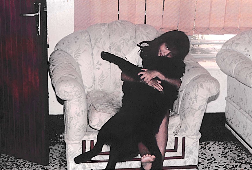 A fotografia mostra Oriana em casa, em Ciudad Ojeda, com seu segundo cachorro, Black, um chow-chow que esteve ao seu lado por 11 anos. Embora aquele dia tenha sido apenas um dia comum, a memória dele permanece especial: Black foi o primeiro cachorro a quebrar o estigma em torno de raças consideradas perigosas, tornando-se presença constante e afetiva na infância de Oriana.