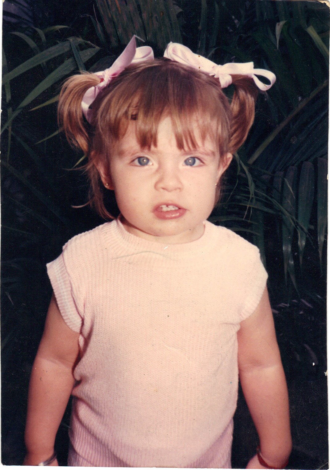 Christiane, com aproximadamente três anos de idade, aparece no quintal da casa de sua avó paterna, espaço doméstico marcado pela convivência familiar e pelas primeiras experiências da infância.