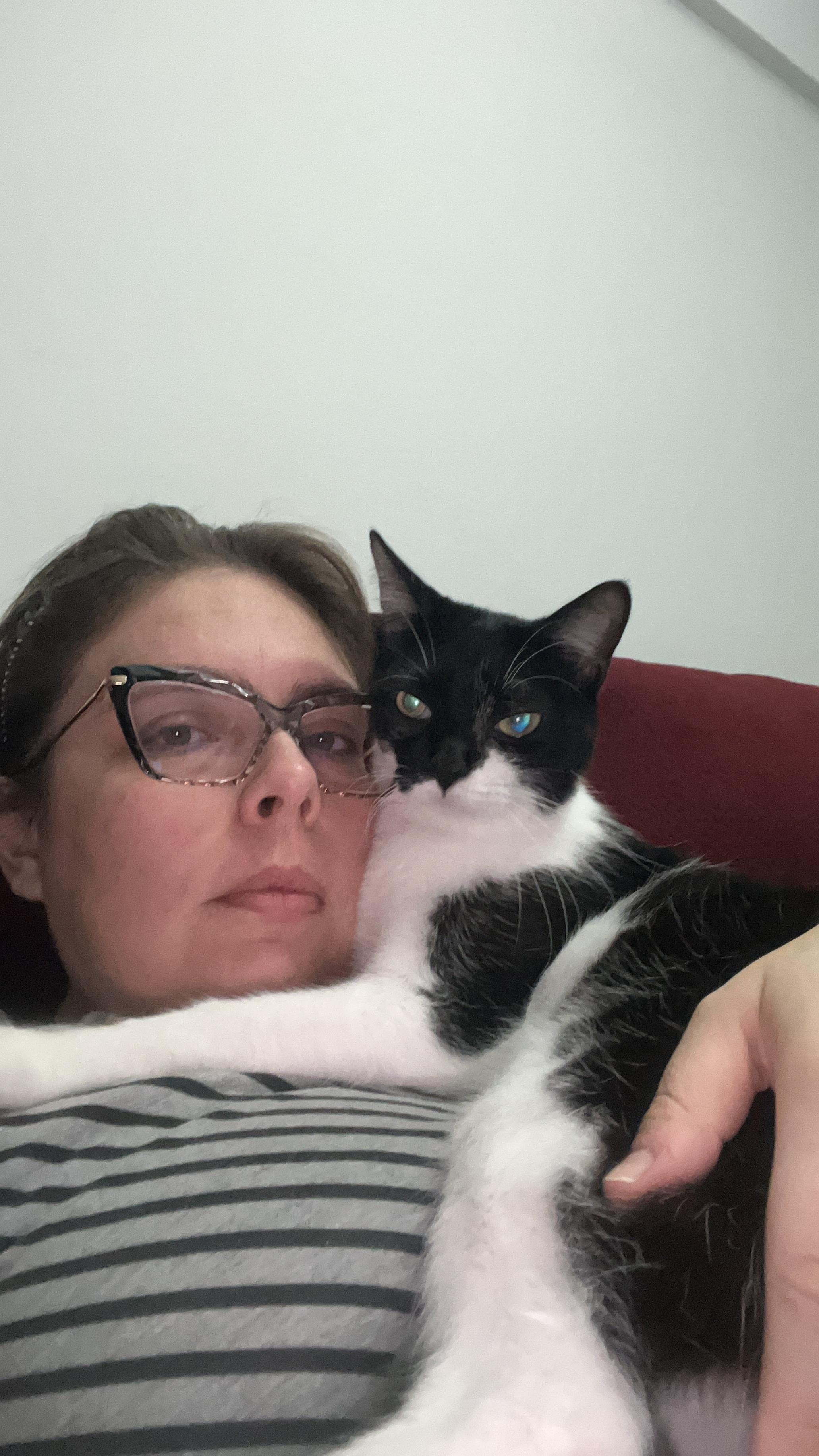 A imagem registra Christiane em um momento de intimidade cotidiana ao lado de um de seus gatos. O gesto de estar abraçada ao animal revela uma rotina marcada pela convivência afetiva com seus companheiros de quatro patas, que fazem parte de sua vida diária e emocional.