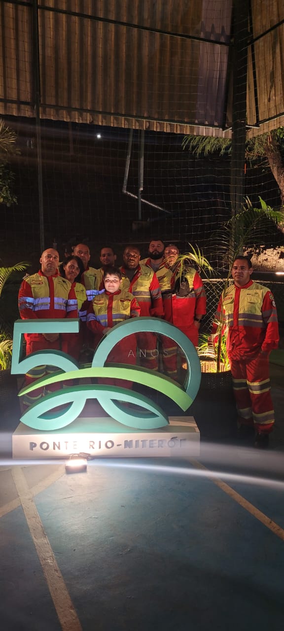 Cristiana junto com a sua equipe de socorristas da Ponte Rio-Niterói, em frente ao marco erguido para comemorar os 50 anos da Ponte.