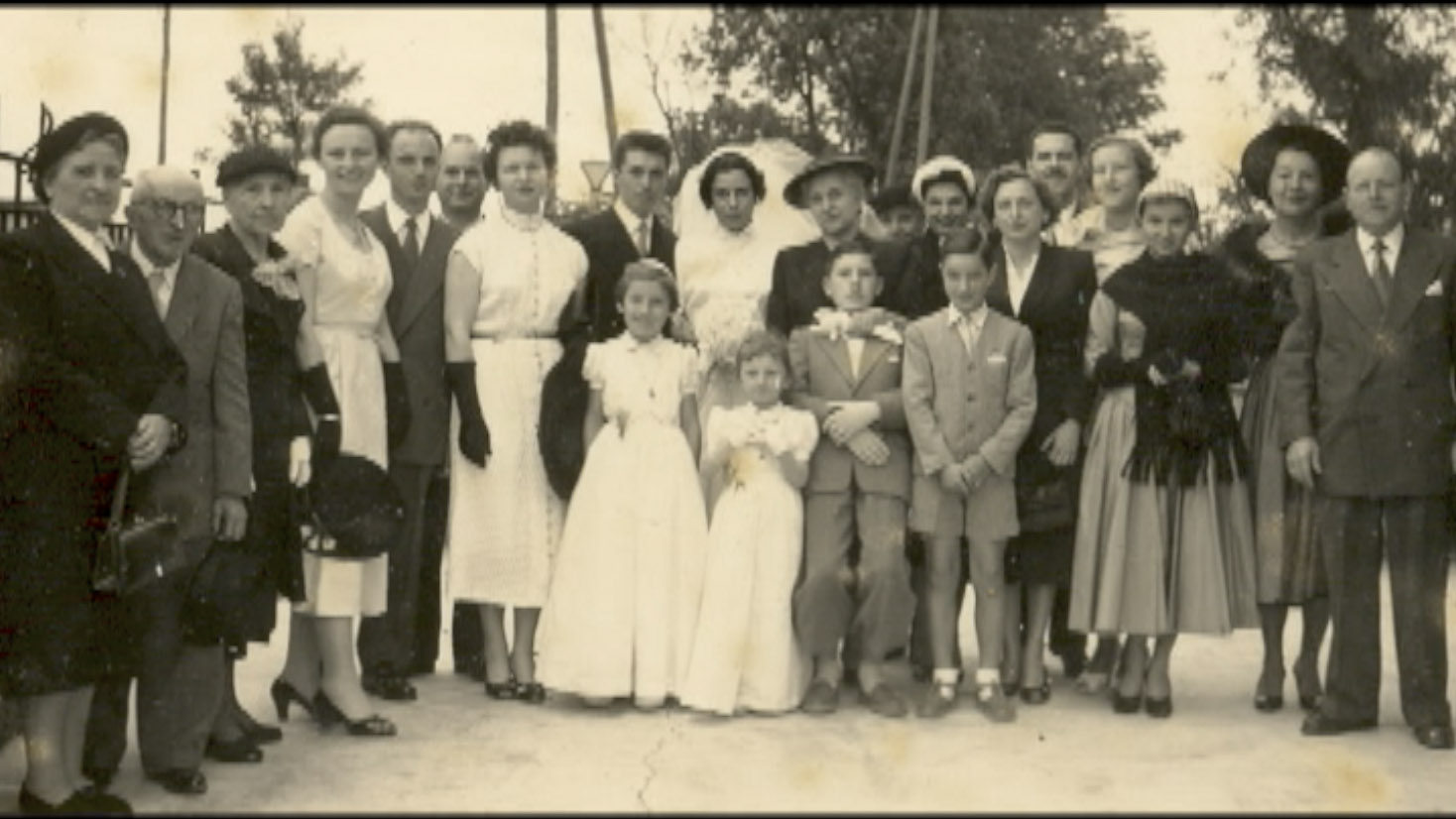 Fotografia de grupo registrada durante o casamento religioso dos pais de Louis Robin, reunindo os noivos, familiares e convidados em celebração familiar.