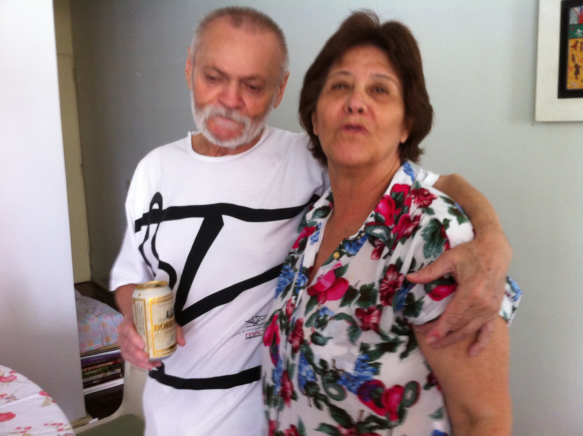 Registro de Felinto e Antonieta, pai e mãe de Vinicius Pereira, em um momento de convivência familiar na sala do apartamento da família.