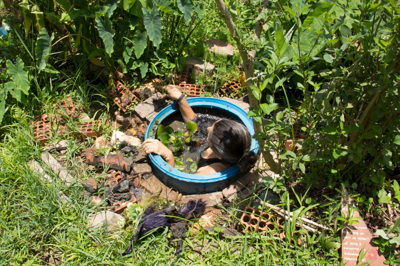 Cláudia Visoni mergulhada dentro da cacimba da Horta das Corujas, em São Paulo, fazendo a limpeza do reservatório.