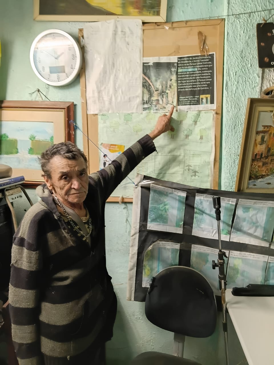 O Sr. Quintino aponta para o mural em sua casa, onde explica que na região o termo 