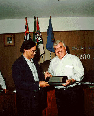 José Ildefonso (à esq.) recebendo placa das mãos do Presidente do Sindicato Varejista de Presidente Prudente, o Sr. Sérgio (Arasuki?), em homenagem pelos serviços prestados ao Centro de Formação Profissional 