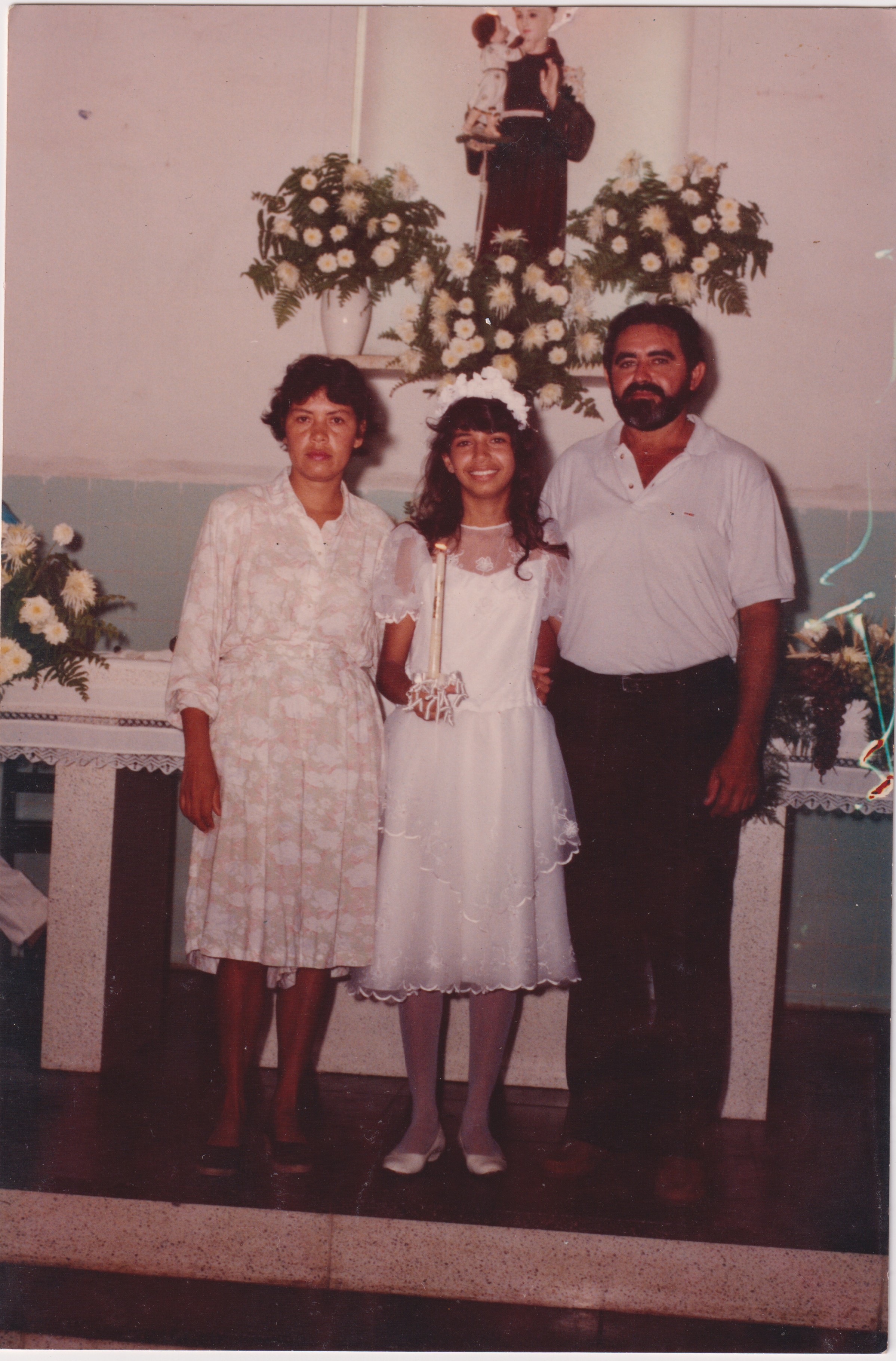 Andrea e seus pais na primeira comunhão dela. A esquerda de Andrea está sua mãe Cícera Medeiros e ao seu lado direito seu pai Aberlado Nunes.