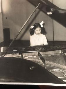 Na mesma época que sua mãe colocou na aula de balé, Rosely também foi fazer aula de piano, onde aprendeu a movimentar seus dedos. Estas aulas foram difíceis, mas a professora era boa, tinha muita paciência. Ela mexia dedo por dedo, em cada tecla do piano. Rosely lembra que era uma dor tremenda, mas mesmo assim ia para aula todos os dias. Foi aprendendo aos poucos, fez aula dos cinco aos quinze anos. Esta foto foi tirada numa audição de piano.