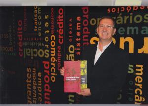 José Robson segura o livro do projeto Memórias do Comércio de São Paulo, no qual foi publicada sua história de vida