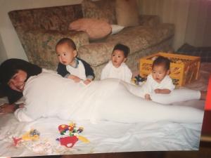 Rosely está deitada curtindo e brincando com seus filhos na sala de casa, Vinicius, Camila e Carolina.