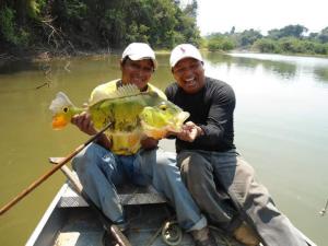 Adriano e seu primo Batiti segurando um tucunaré no Lago Furo Grande, na Terra Indígena Karipuna.