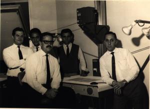 O BNDE foi um precursor do sistema de microfilmagem e possuía, no prédio da Avenida Rio Branco, o sistema mais moderno do Brasil segundo a Kodak. Henio estava presente na inauguração do sistema. Esq.-dir.: Aluísio, Valter, Antônio Augusto, Orlando, Henio.