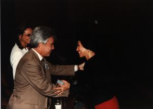 Maria Lídia recebe medalha de vinte anos de trabalho das mãos do diretor da área de infraestrutura do BNDES.