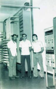 João e colegas nas instalações de uma central telefônica, em sua primeira viagem a trabalho pela Companhia de Telecomunicações do Brasil Central (CTBC). Estava em uma sala onde funcionavam quatro equipamentos de transmissão: 2-AF Ericsson, K-32 da Stander Eletronic, DQ-12 alemão e DQ-12 da International Múltiplo. Esq.-dir.: Dázio, Clélio Antonio Simioni e João Batista Coura.